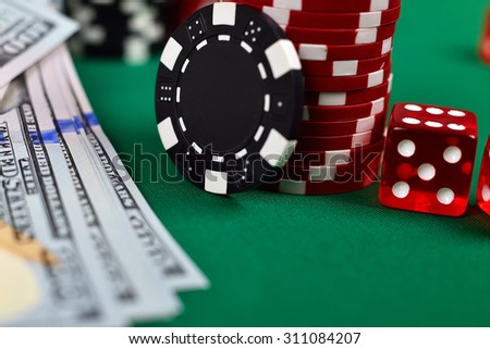 Poker chips, money and dice on a gaming table