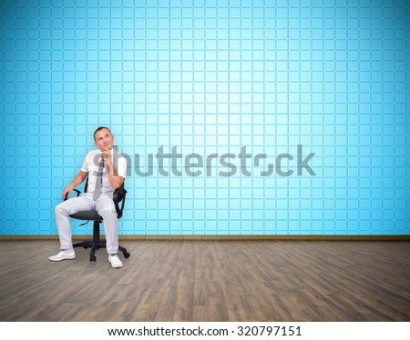 businessman sitting in room with big plasma tv wall