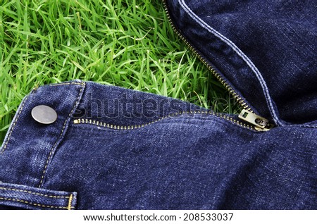 Jeans background with a green grass.