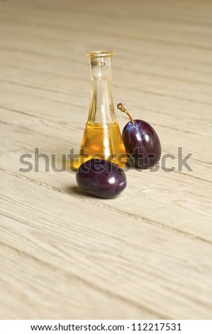 Plum brandy over a wooden background