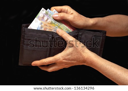 Black wallet with money in hands. Swiss francs banknotes.