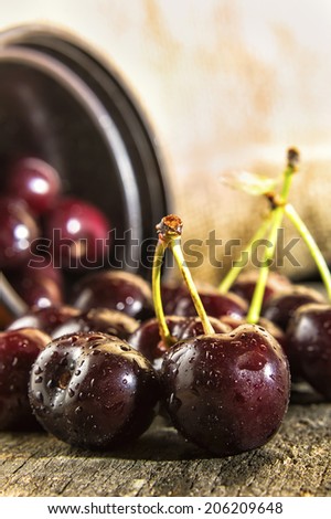 Cherries on wooden table with water drops.