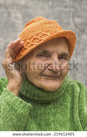 Elderly woman holding hand close to an ear. Hearing problems.