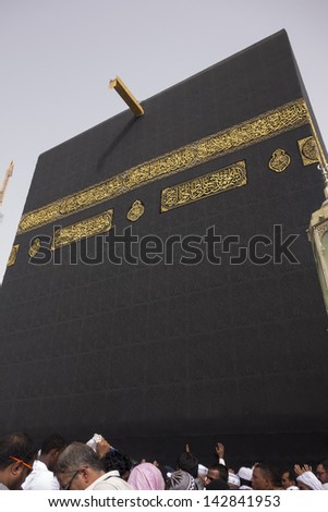 MECCA - JUNE 7 : A close up view of Muslim pilgrims touch Kaaba cloth at Masjidil Haram Mosque June 7, 2013 in Mecca. Muslims all around the world face the Kaaba during prayer time.