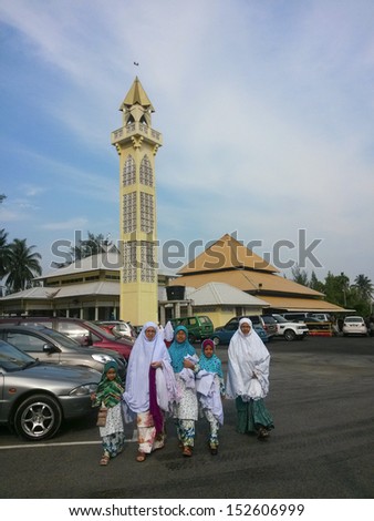 KUANTAN, MALAYSIA-AUG. 8: A group of unidentified Muslim women and kids finish praying at a local mosque in Kuantan, Pahang, Malaysia on August 8, 2013. Muslims celebrate eid after a month of fasting.