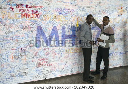 KUALA LUMPUR INTERNATIONAL AIRPORT - MARCH 17: Unidentified men write messages and prayers for Malaysia Airlines Boeing 777-200ER MH370 on March 17, 2014 in KLIA, Sepang, Malaysia.