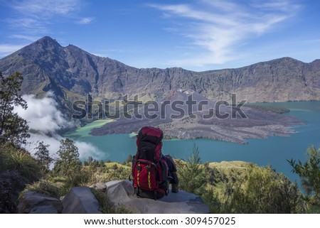 A mountain hiker or trekker takes a break to enjoy beautiful view on top of a mountain.