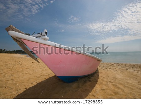 Front view of an anchored pink colored fishing boat.