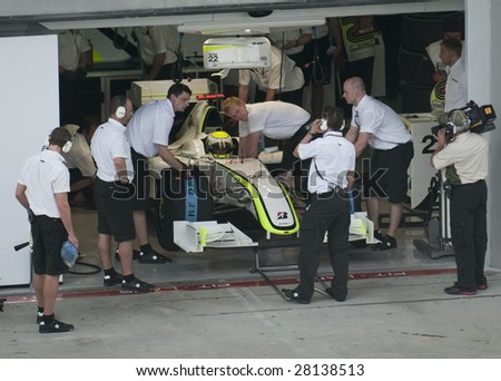 SEPANG, MALAYSIA - APRIL 3 : Pit crews prepare Jenson Button\'s car of Brawn GP F1 Team during practice session at Malaysian F1 Grand Prix April 3, 2009 at Sepang International Circuit in Sepang.