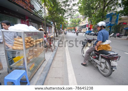 HANOI, VIETNAM - MAY 24: An unidentified road side baguette seller sells fresh baguettes in Hanoi on May 24, 2011. According to UNICEF, gross national income (GNI) for Vietnam in 2009 is USD$1,010.