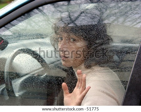 A woman in a car behind the wheel.