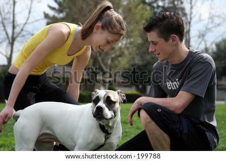 Teenagers playing with a dog in the park