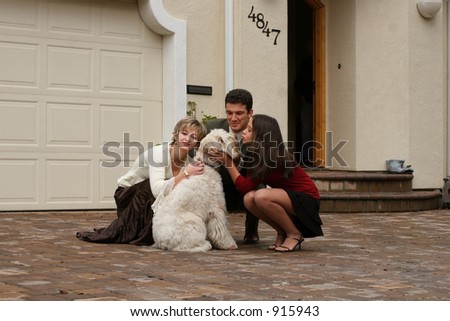 Happy family with a dog in front of the home