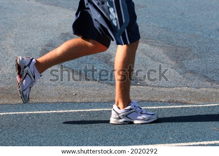 Feet of a running man on a blue track