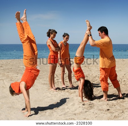 Family in orange clothes having fun on the beach