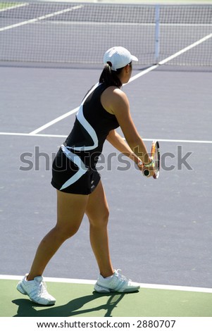 Woman serving the ball at the professional tennis tournament