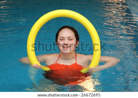 Fat girl is engaged in aerobics in water with  aqua noodles