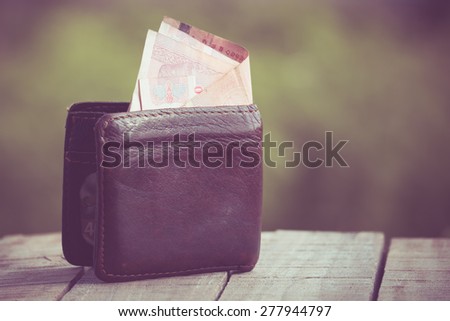 Money in leather wallet with filter effect retro vintage style