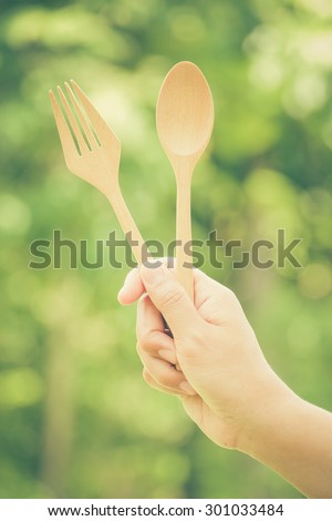 Woman hand and wooden spoon with filter effect retro vintage style