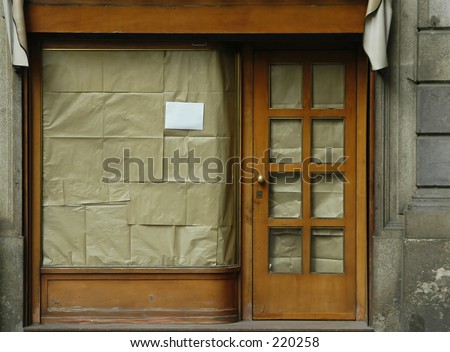 Storefront, view blocked by brown paper in windows.  Blank white notice for your text.
