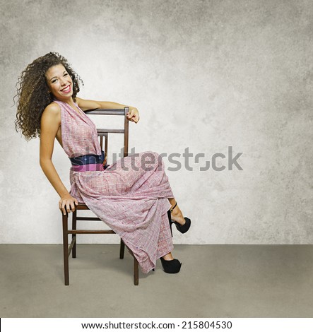 A smiling female figure pose sitting on a chair