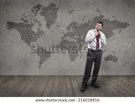 In one room a well-dressed man adjusts his tie