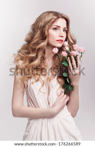 Beautiful young model with pink roses, bright makeup and manicure. Tender portrait studio shot, st valentine