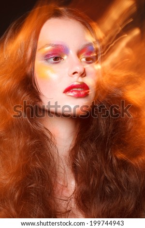 attractive young fashion model with bright art colorful make up fire lights, studio shot for cover magazine