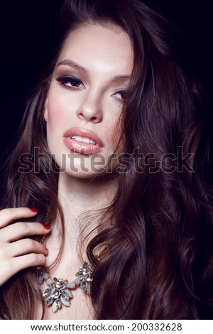 Young model with big lips and make up, brunette, black background Fashion look
