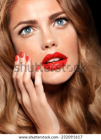 Beautiful young model with red lips and red manicure