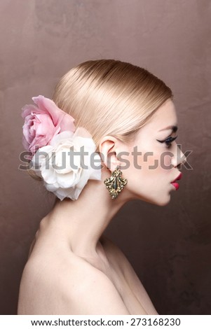 Fashion beauty model with classic make up and blonde hair. Flower. Nude skin.