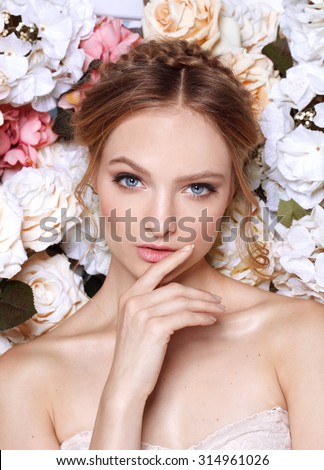 Portrait of a beautiful fashion bride, sweet and sensual. Wedding make up and hair. Flowers background. Art modern style. Blue eyes