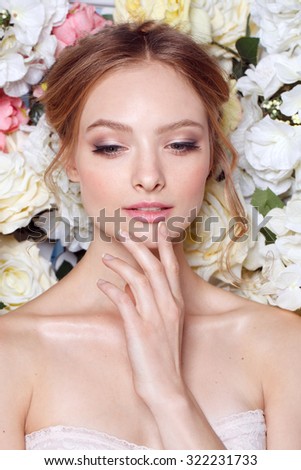 Portrait of a beautiful fashion bride, sweet and sensual. Wedding make up and hair. Flowers background. Art modern style. Blue eyes. Manicure.