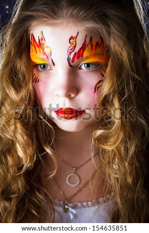 Pretty girl with face painting of sign of the zodiac Aries