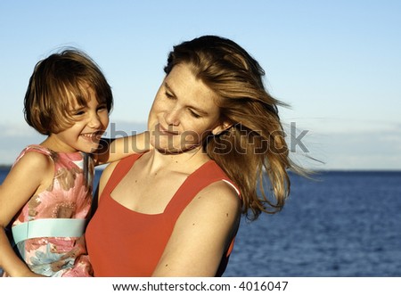 Girl and mother arm in arm in summer light