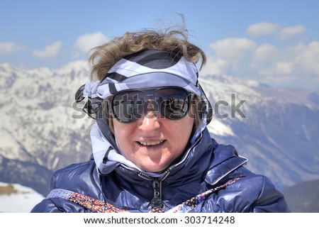 DOMBAY, RUSSIA - May 03.2015: Smiling woman in sunglasses on a background of mountains