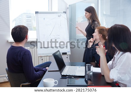a group of businessmen in a meeting looking at the board