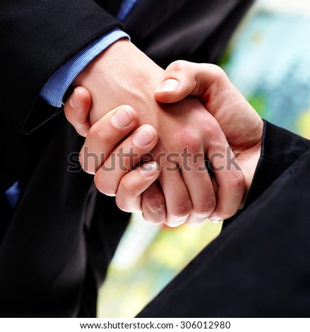 two young business executives shaking hands close-up