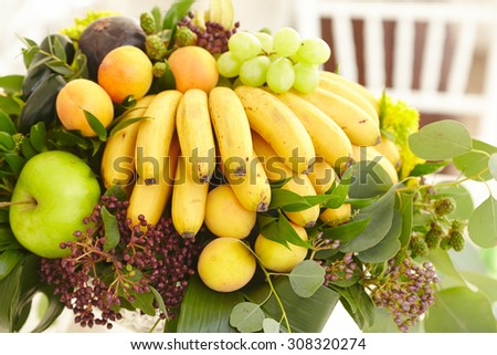 Fruit basket close-up: bananas, apples, grapes, apricots