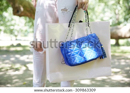 handbag and shopping bags in the hands closeup