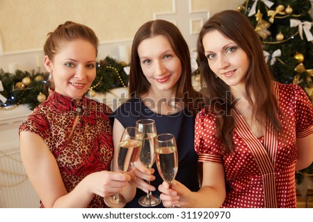 three beautiful girls on New Year\'s party with champagne