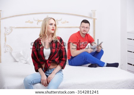 woman and a man in a quarrel sitting on the bed