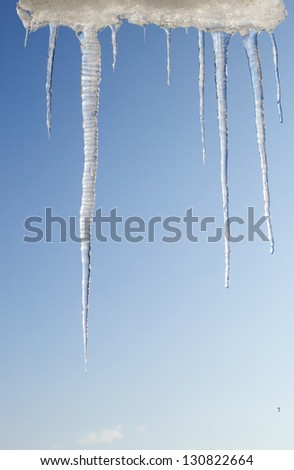 There are icicles frame on cloudy sky background