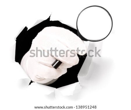 Man with gloves is holding magnifying glass through a hole in white paper
