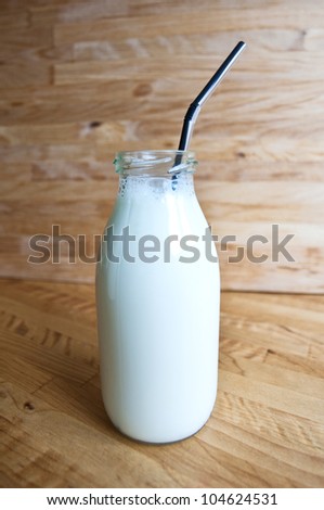 a bottle of milk with drinking straw, a bottle of fresh milk,  fresh milk