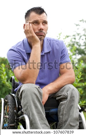 disabled young man in wheelchair with a pensive facial expression, sad look
