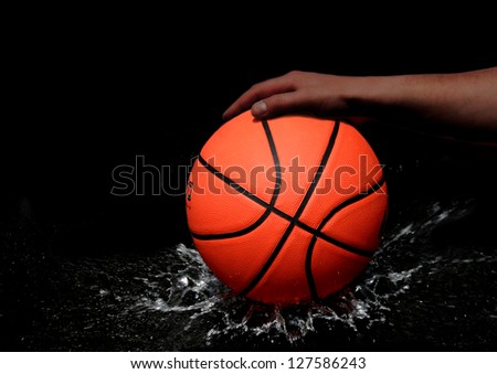 basketball against dark background is pitched on wet ground