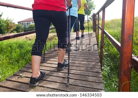 three elderly women to keep fit and healthy with nordic Walking in summer
