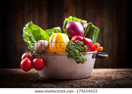 fresh vegetables in rustic pot on black Background, mystic light