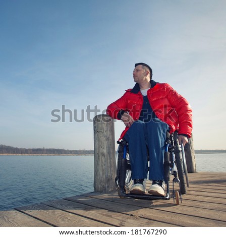 handicapped man in a wheelchair watching the sea